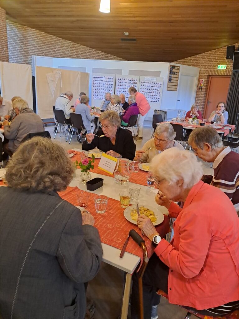 oudere mensen om tafels zijn aan het eten